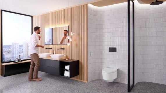 Man in badkamer staand voor Geberit Option Plus Square spiegel en zwart Geberit ONE badkamermeubilair (© Geberit) Man in badkamer staand voor Geberit Option Plus Square spiegel en zwart Geberit ONE badkamermeubilair (© Geberit)