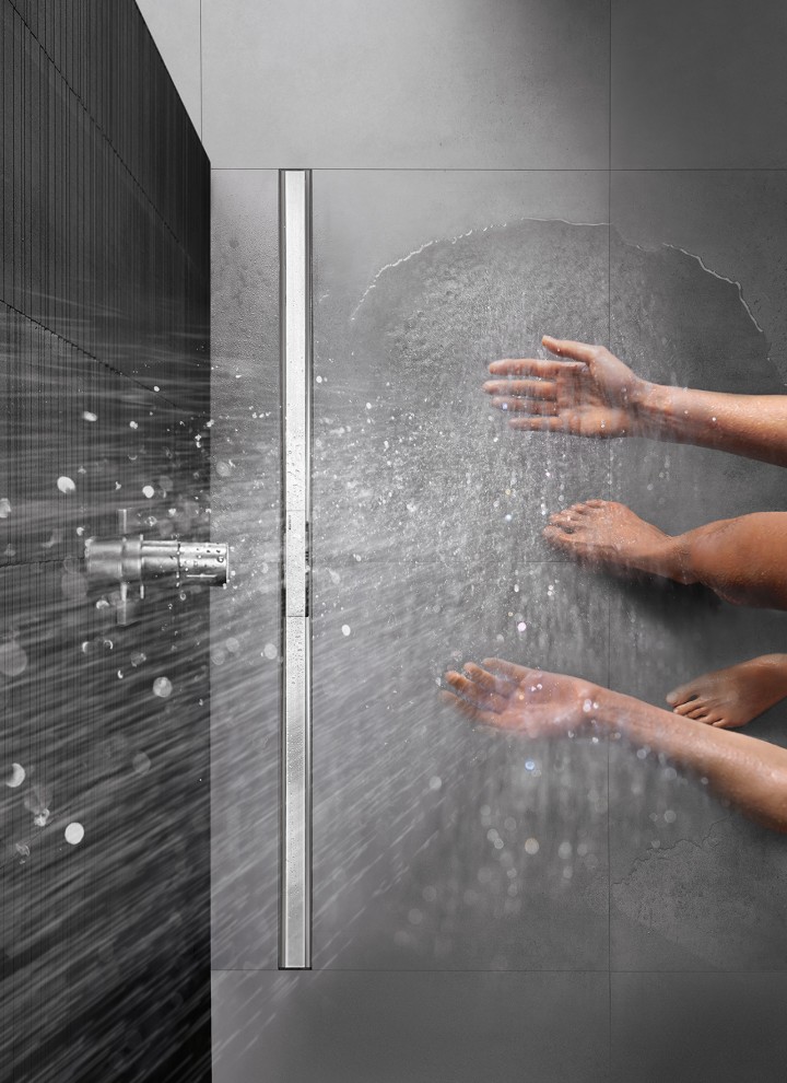 Person showering in a floor-even shower with CleanLine