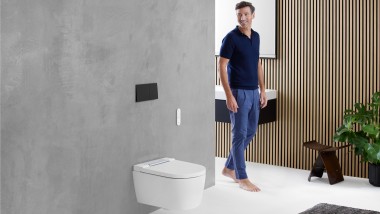 Man in de badkamer kijkt naar de wc-opstelling met een Geberit wc