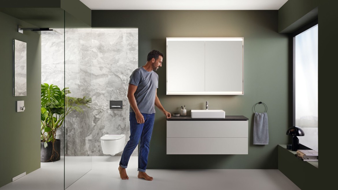 Man in bathroom with bathroom furniture from Geberit ONE