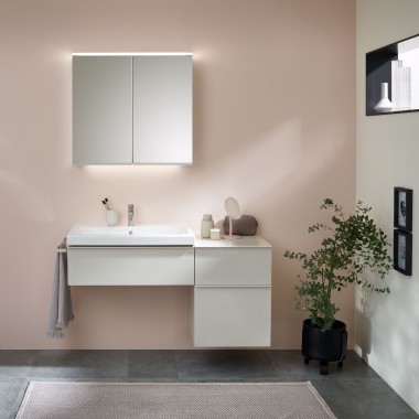 Lavabo avec meubles de salle de bains, lavabo et armoire de toilette de Geberit devant un mur pastel