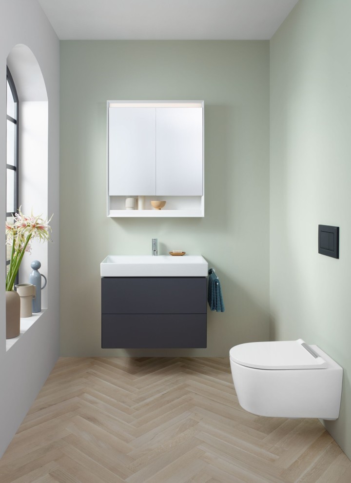 Vue dans un WC d'invités avec WC suspendu, armoire à miroir et sous-meuble de la série Geberit ONE