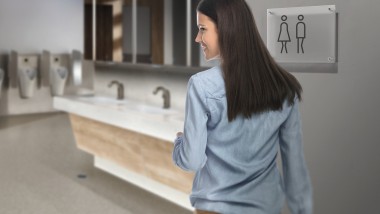 Donkerharige jonge vrouw in een openbaar toilet