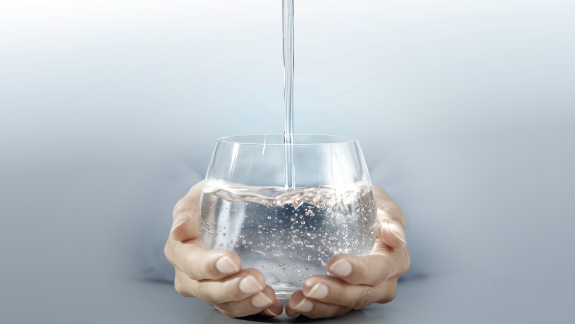 Persoon met een glas water in zijn handen Persoon met een glas water in zijn handen