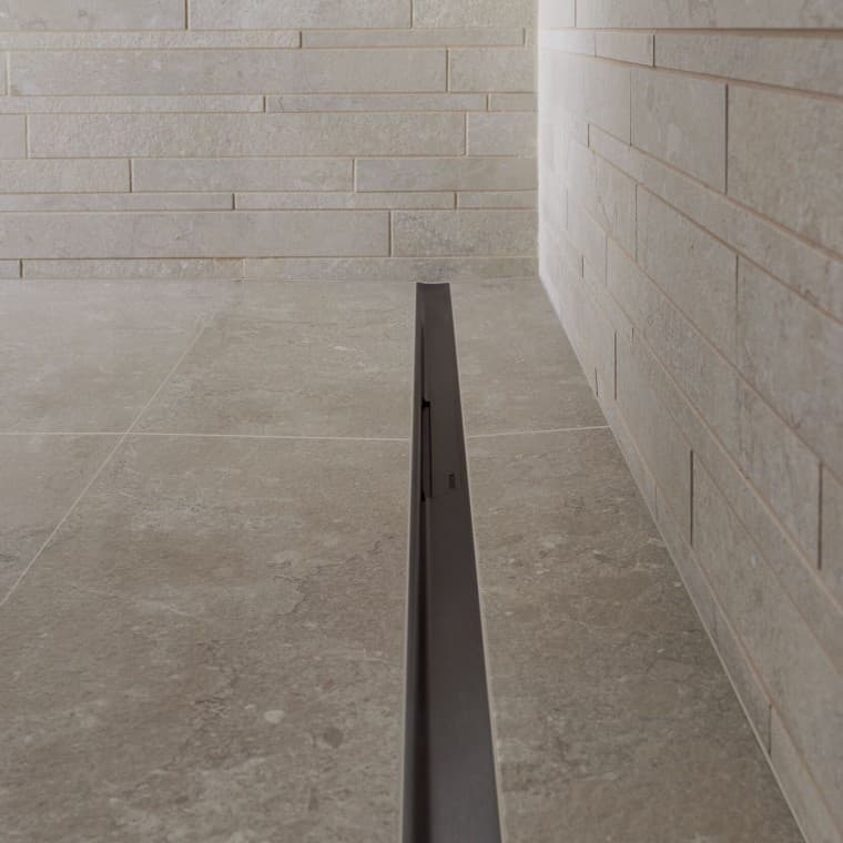 Het water loopt weg via een elegant profiel van roestvrij staal. Het water loopt weg via een elegant profiel van roestvrij staal.