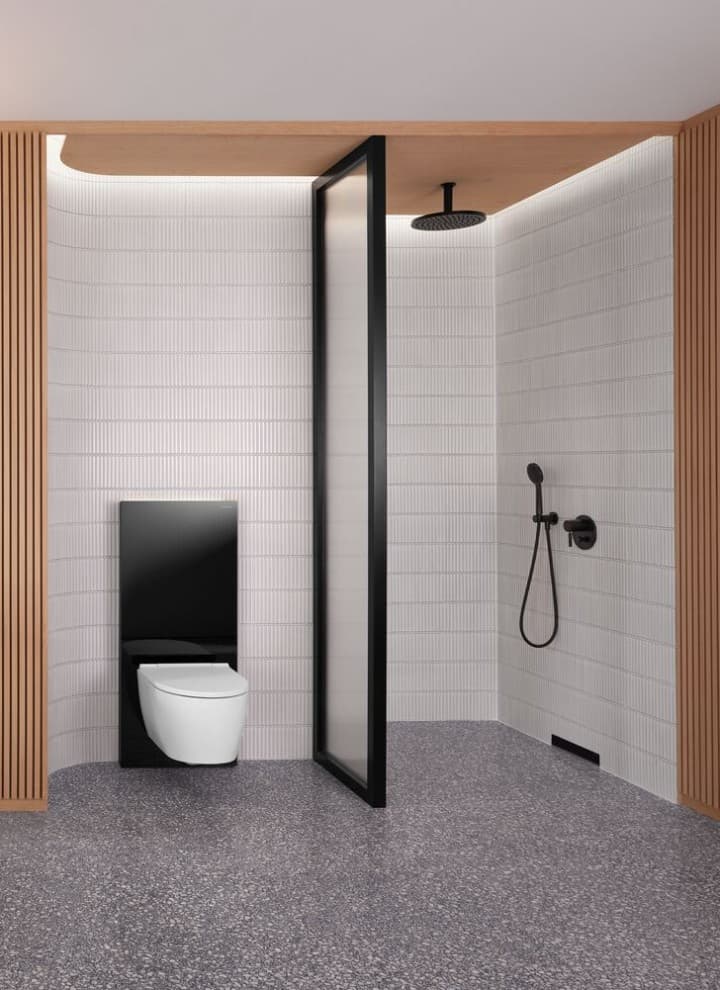 Een badkamer met een houten wand en een douche- en wc-opstelling in zwart-wit Een badkamer met een houten wand en een douche- en wc-opstelling in zwart-wit
