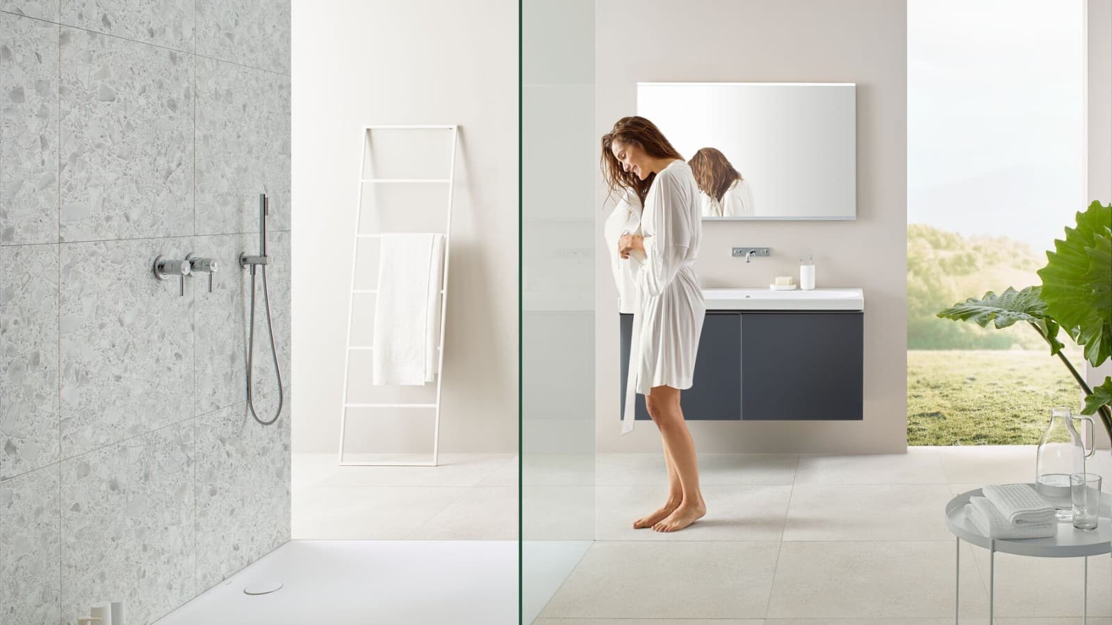 Woman in bathroom with walk-in shower and Geberit Olona shower surface Woman in bathroom with walk-in shower and Geberit Olona shower surface