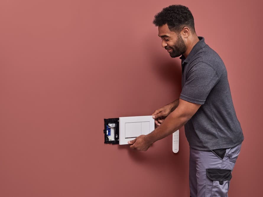 Man installeert Geberit DuoFresh-geurextractie Man installeert Geberit DuoFresh-geurextractie