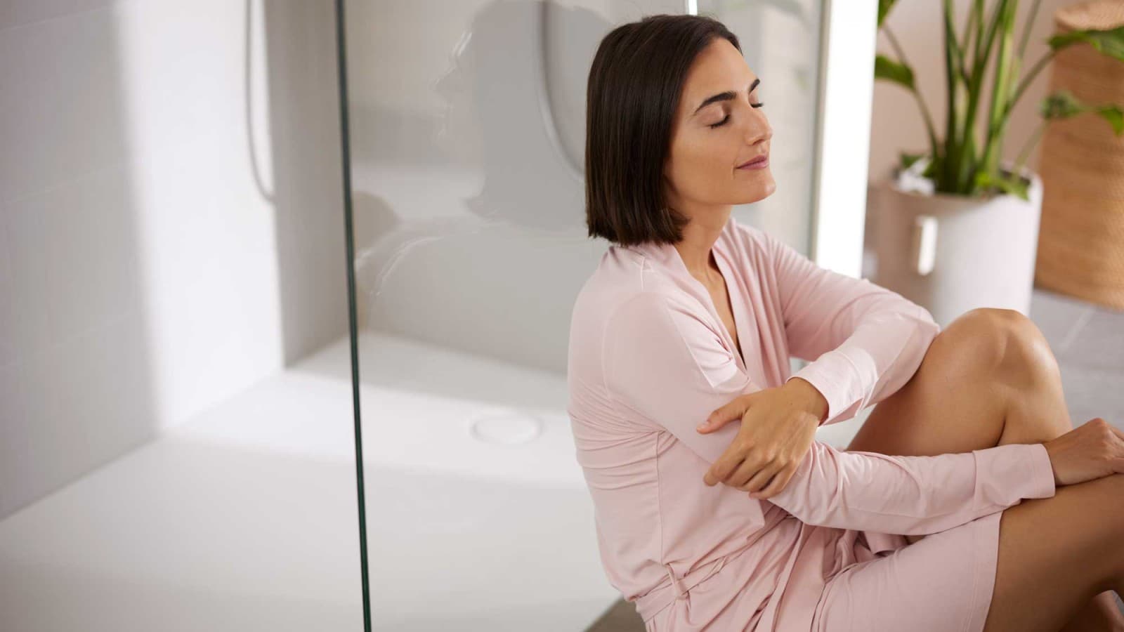 Vrouw zit in de badkamer voor de douche Vrouw zit in de badkamer voor de douche
