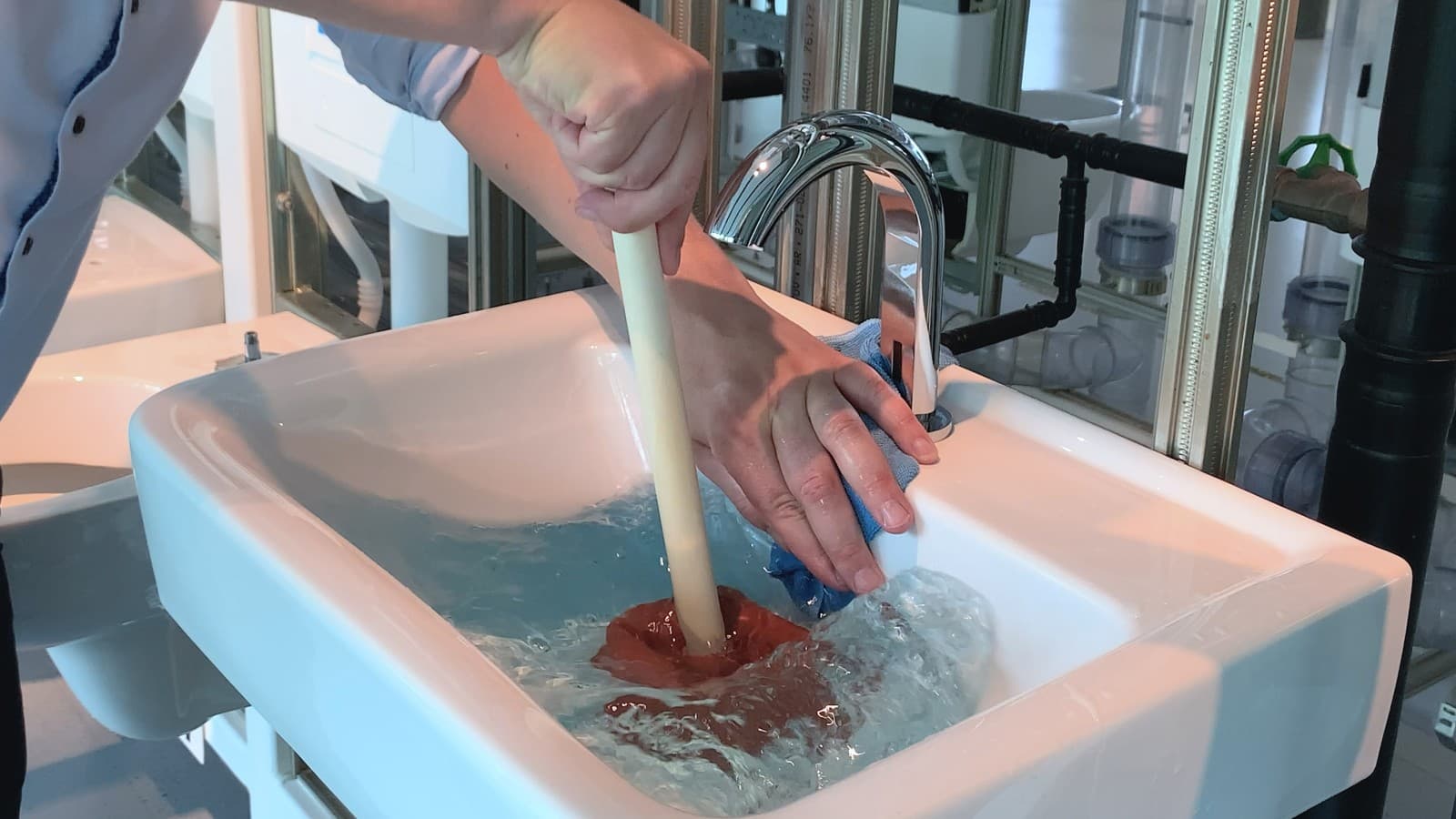 Met de hand en een doek de overloopopening afdekken Met de hand en een doek de overloopopening afdekken